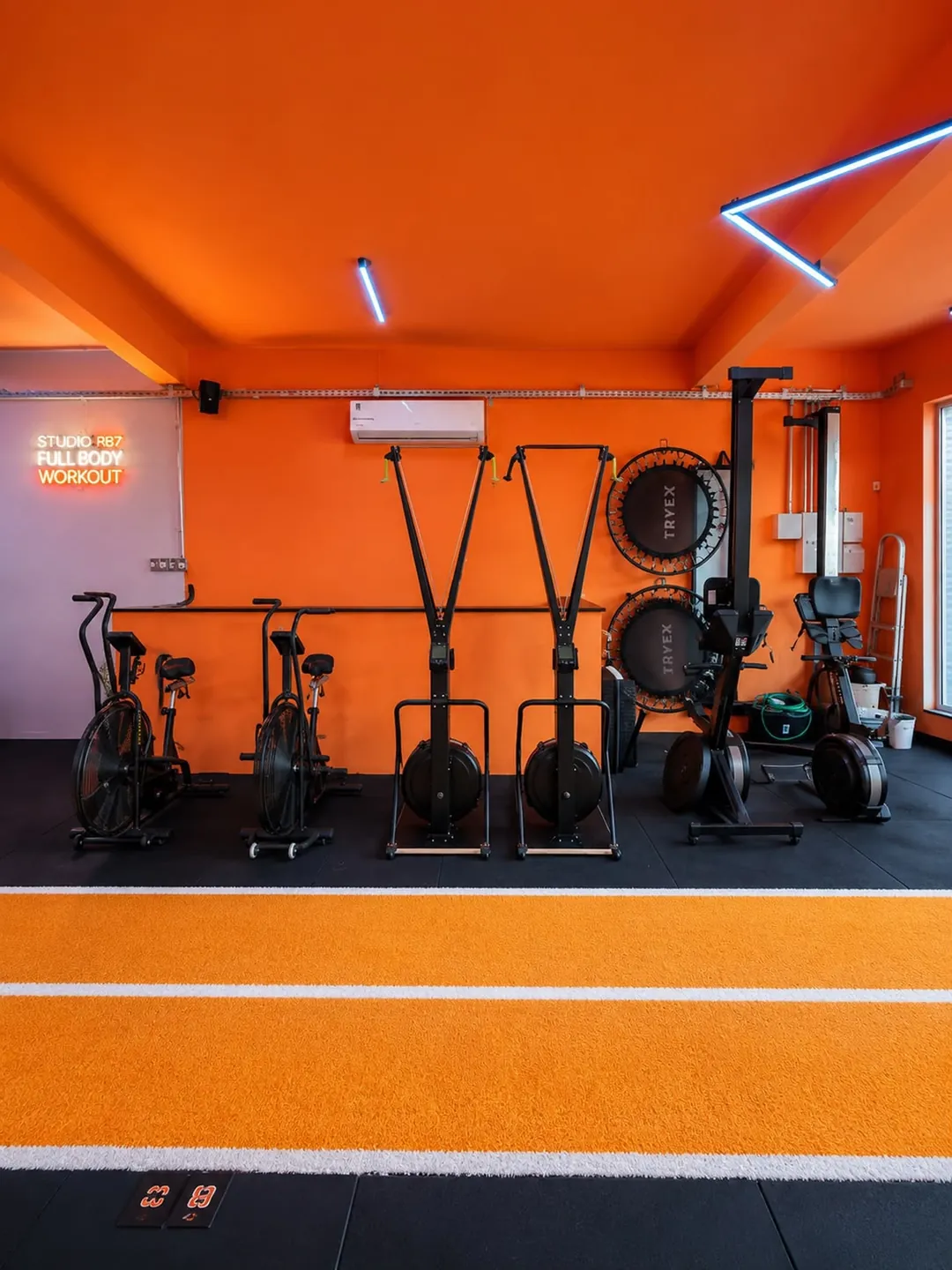 Sala de parede laranja com bikes e equipamentos
